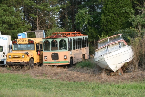 Vehicles in a junk yard.  Only in Alabama would one see a school bus, a trolley and a boat, side-by-side.  An FYI- there was a tractor trailer to the right!!